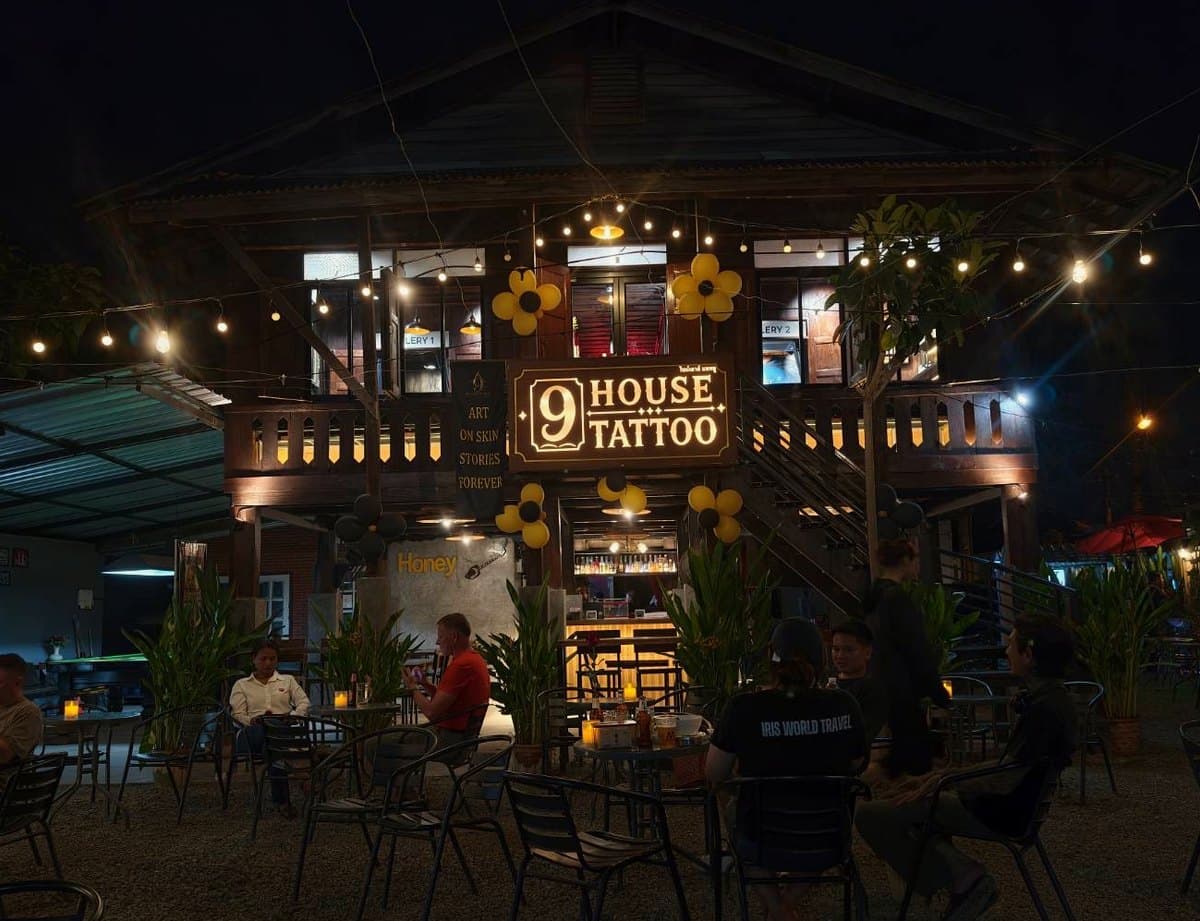 9 House Tattoo at night — a two-storey Lanna timber house with a lit sign