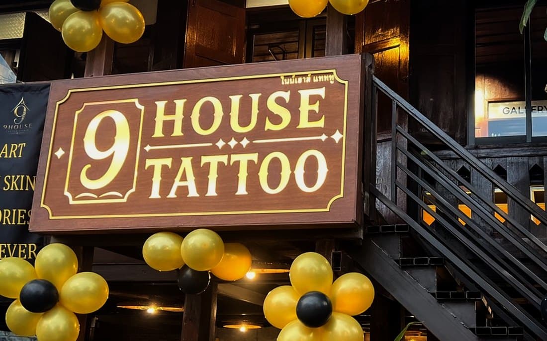 The black steel staircase up to 9 House Tattoo, beside the lit sign